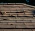 Close-up view of damaged asphalt shingles on a Houston residential roof showing curling edges and missing granules, highlighting the need for roof replacement Houston services